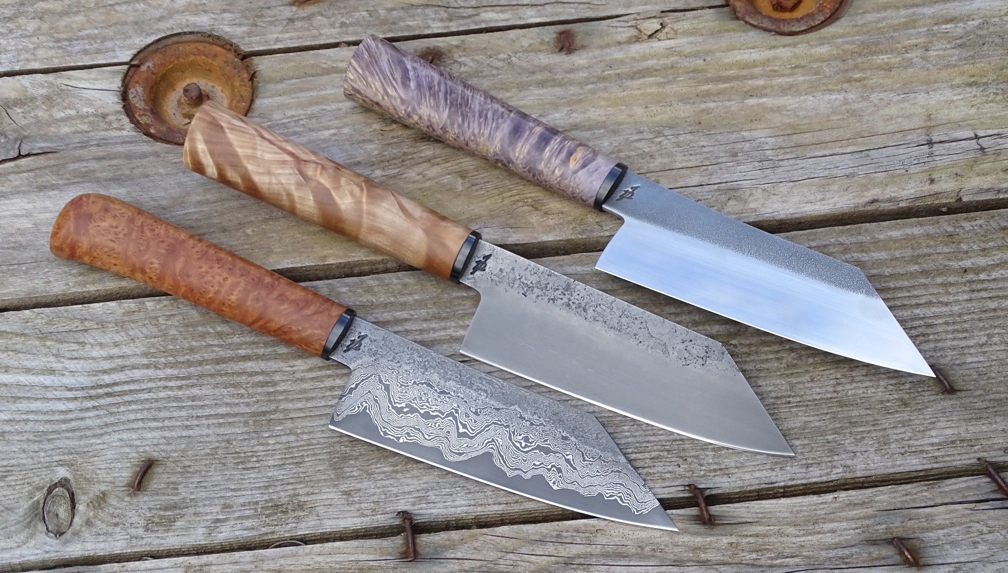 Trois couteaux de cuisine à lame damas et manches en bois précieux